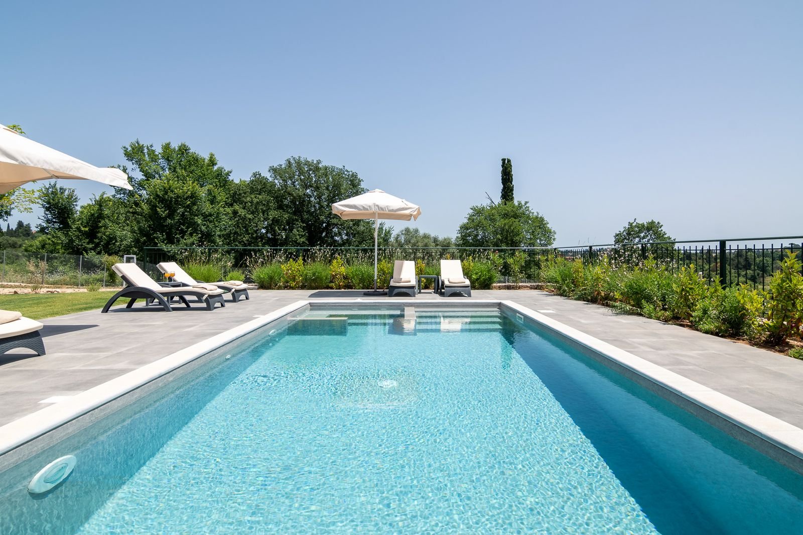 Private pool with sunbeds at Villa Agapi in summer